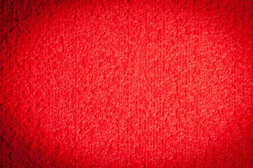 textured textile red surface for background and wallpaper with dark vignetting gradient