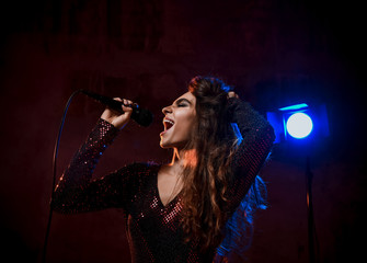 Beautiful singing girl curly afro hairstyle. Beauty woman singer sing with microphone karaoke song...