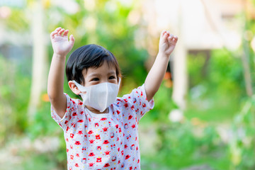 Child wearing a protective face mask on a city street with air pollution. Facial hygienic mask for Safety outdoor environmental awareness concept And protect disease virus against germs dustpm2.5