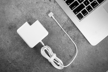 magSafe 2. Apple Power Adapter laptop charger.  MacBook keyboard a metal background