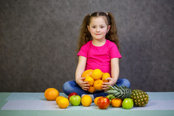 A little girl six years old loves fruits very much. Vitamins and healthy eating.