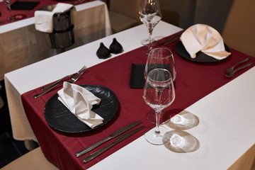 Table for two persons in a restaurant decorated with a red tablecloth and black plates