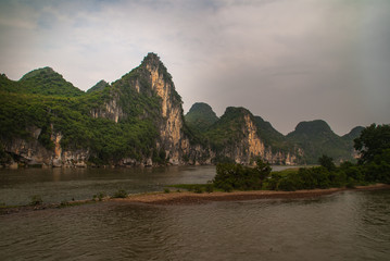 Guilin, China - May 10, 2010: Along Li River. Landscape of karst mountain under rainy cloudscape...