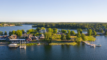 Fototapeta na wymiar Beautiful aerial view photo from drone on Trakai city, located near Galve lake in Lithuania. Surrounded by beautiful lakes and green islands with plenty of water attractions for tourists available. (s