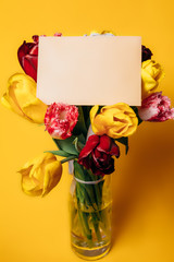 Bouquet of tulips with a note on a yellow background.