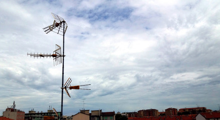 Old television antenna on the roof of the house. A photography of an antenna that is used to receive analog signals.