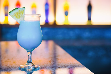 Blue Hawaii alcohol cocktail with pineapple on bar counter