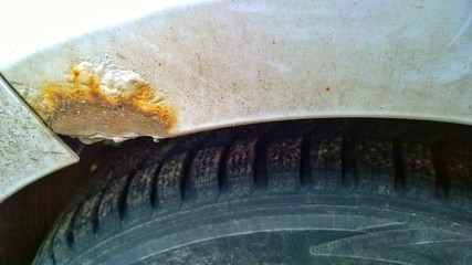 Sheet metal corrosion of a dirty old car. Rusty surface, background, damaged texture from road salt. How to remove steel rust from a vehicle. Protection and painting auto concept. Professional repair