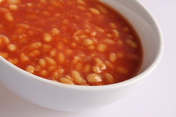 A studio photograph of baked beans in a tomato sauce
