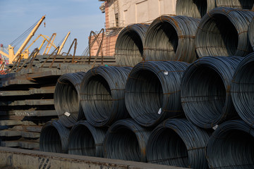 Sea transportation of cargo. Bays of steel wire at sea berth prepared for loading on cargo ship. Thin metal reinforcement wound into bays at the metal products warehouse