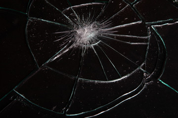 Broken glass with cracks on black background