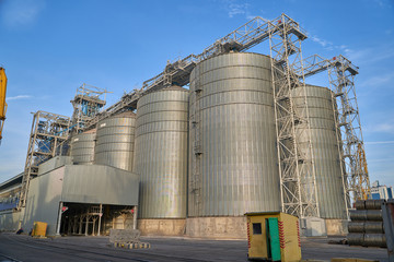 Obraz premium Port grain elevator. Industrial sea trading port bulk cargo zone Railway wagon in grain terminal