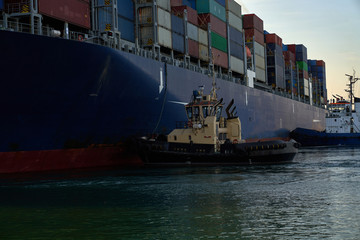 A large merchant ship container vessel in coastal waters of ocean. A merchant ship is moving around...