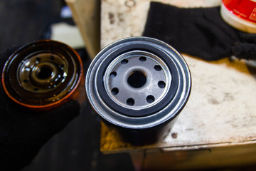 Replacing the oil filter on a car engine. new and old filter.