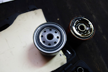Replacing the oil filter on a car engine. new and old filter.