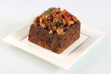 A small rich fruitcake photographed against a white background