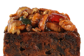 A rich fruitcake photographed against a white background