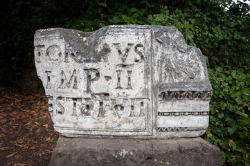 Broken marble stone with latin inscription on display at the Forum, Rome