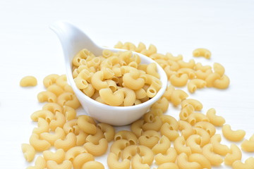 Italian short pasta, on white wooden background