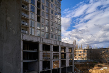 Fototapeta premium Construction site. High rise Building under construction. Construction of high-rise residential building