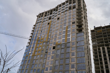 Fototapeta premium Construction site. High rise Building under construction. Construction of high-rise residential building