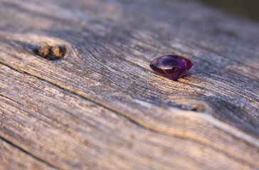 Purple amethyst gemstone on wooden background