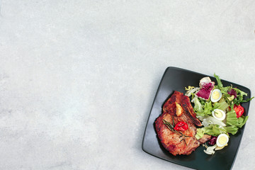 Roasted pork steak with fresh vegetable salad