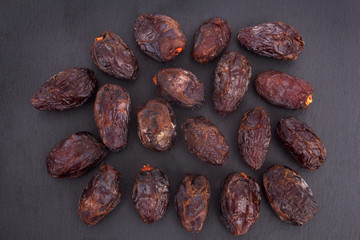 A studio photograph of dates against a slate background