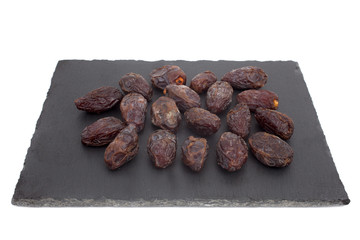 A studio photograph of dates against a slate background