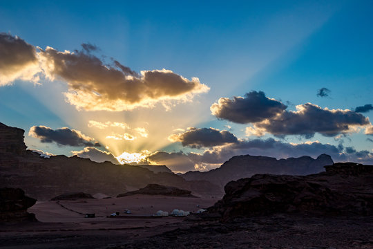 Kingdom of Jordan, Wadi Rum desert, impressive sunset sky and light over desert in darkness and shadows. Lovely travel photography. Beautiful desert could be explored on safari. Colorful image