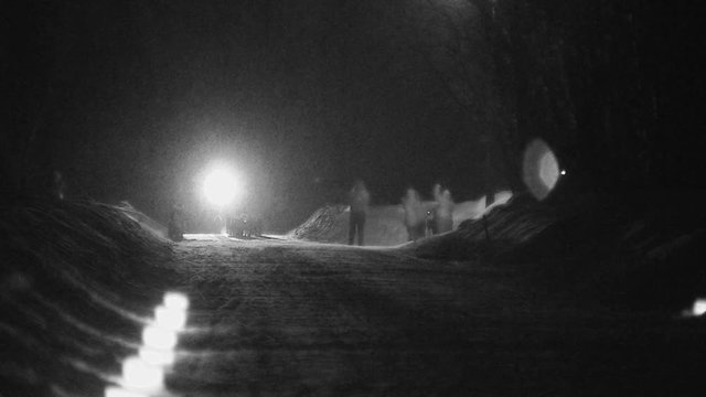 Sled Dogs Coming Toward Camera At Night While Snowing