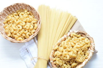 Italian long and short pasta, on white wooden background