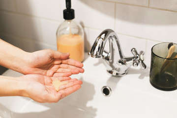 Washing hands. Taking soap on hands palm in bathroom, hands washing to prevent coronavirus epidemic. Prevention of flu disease. Washing hands in proper technique