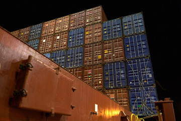 Obraz premium Container ship in port at container terminal. Ships of container ships stand in terminal of port on loading, unloading container at night time.