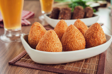 Brazilian appetiser coxinha de frango and two glass of beer