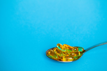 Spoon full of pills for weight loss on a blue background