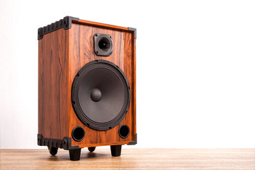 Loudspeaker box amplified on wood table on white background