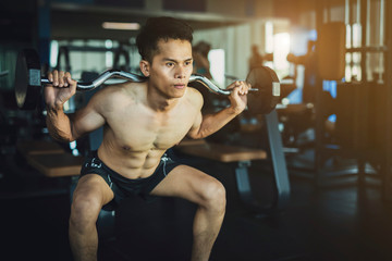 Fototapeta na wymiar Young man exercising in the gym