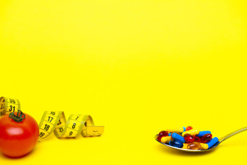 Spoon full of pills for weight loss on a yellow background
