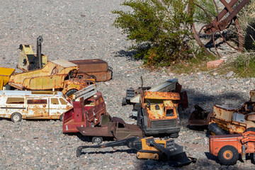 Antique toy metal trucks rusted in the desert sun