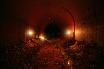 Dark dirty flooded abandoned vaulted drainage tunnel