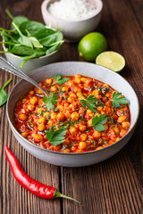 Indian meal, spicy chickpea curry with spinach in a bowl served with rice