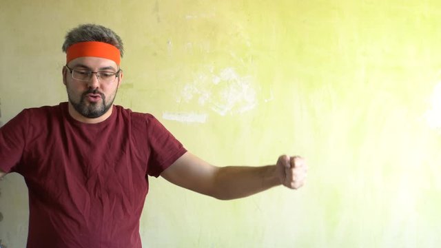 Bearded man against the wall. Good mood. Engaged in martial arts. Repair work in the room. Frick.