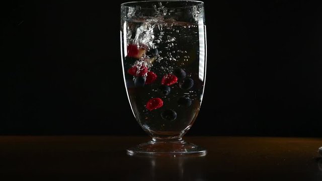 isolated Fruit falling into large glass vase in slow motion 120fps down to 24