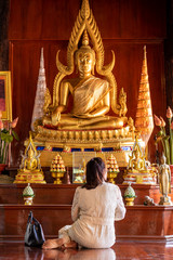 The back of the woman sat to pay respect to the Buddha image.