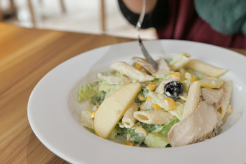 Close up of women eating salad at cafe 