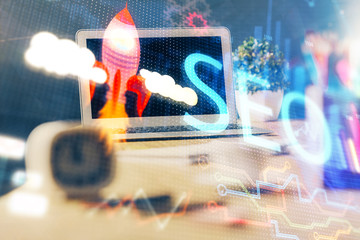 Multi exposure of table with computer and seo drawing hologram. Search optimization concept.