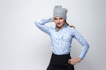 Youth Lifestyles. Portrait of Happy Caucasian Blond Girl in Warm Winter Hat and Blue Shirt Posing on White Background.