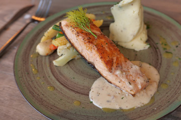 Roasted salmon with french fries and vegetable salad.