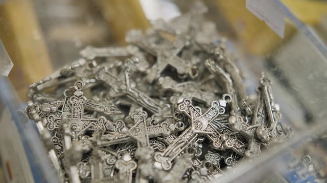 Super close up shot of metal/silver crosses randomly stacked in souvenir shop., Selective focus.